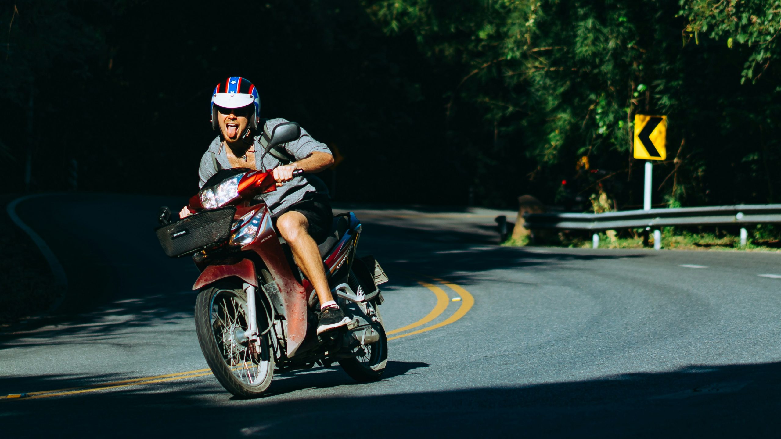 Man riding a moped abroad with helmet on