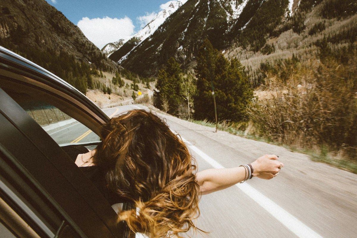 Woman leaning out of a car with wind in her hair