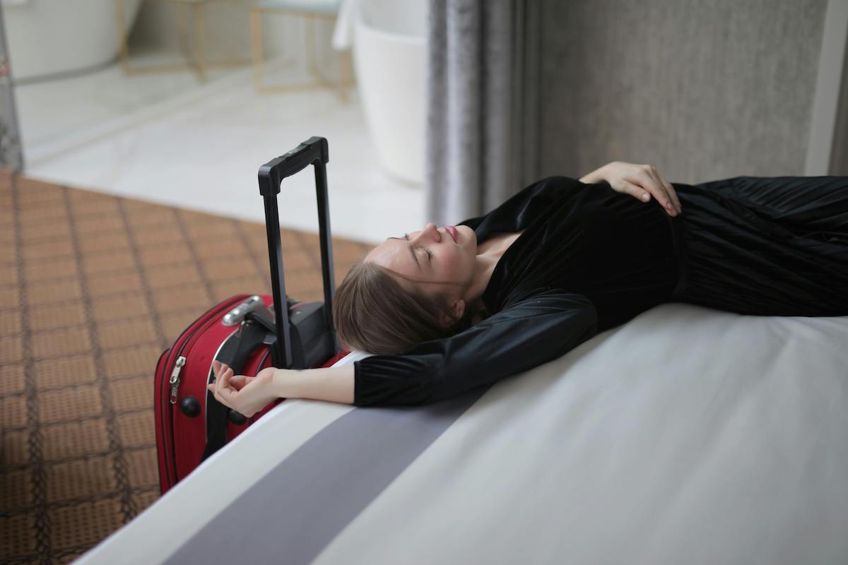 Woman In Black Long Sleeve Dress Lying On A Bed