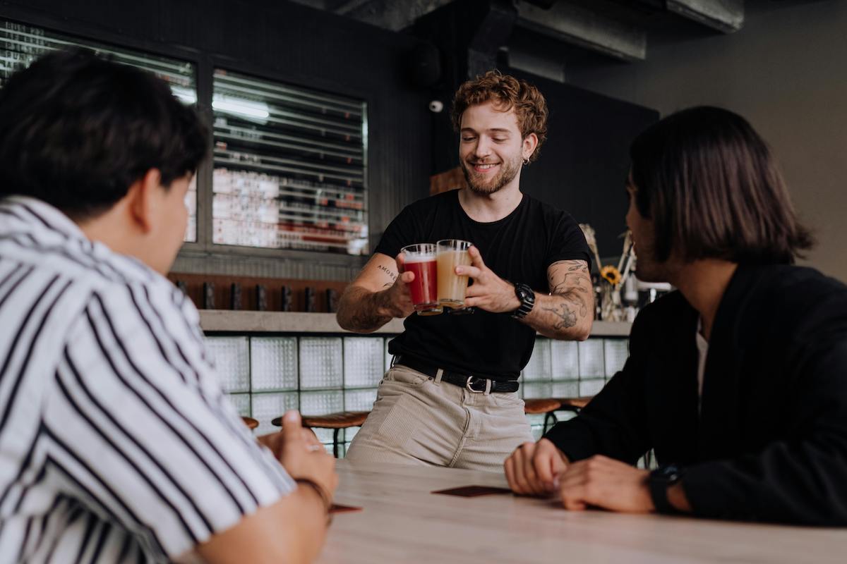 Man Holding Glass Cups with Beverages