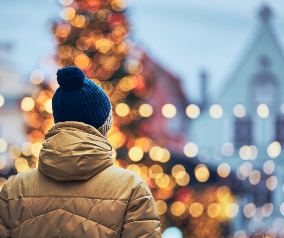 A man wearing a bobble hat in a winter market