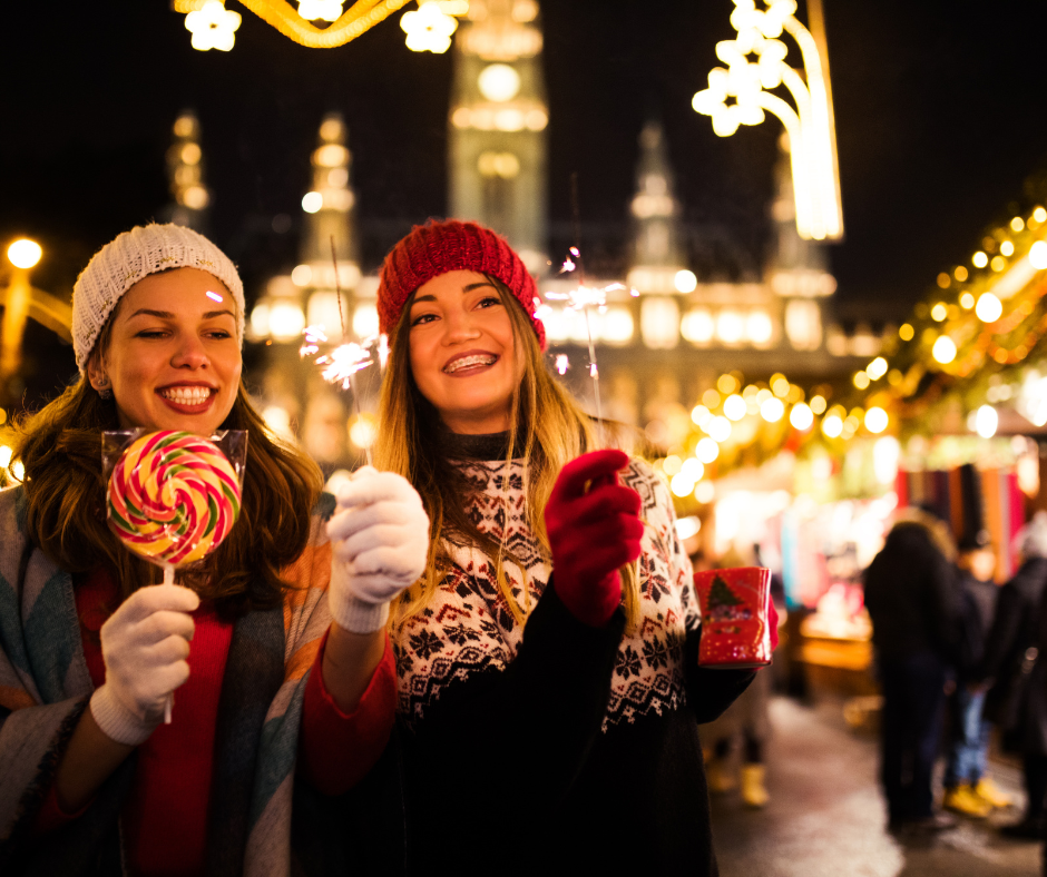 Two women smiling at a Christmas market in Europe