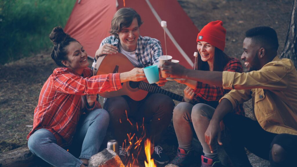 Friends laughing around a camp fire