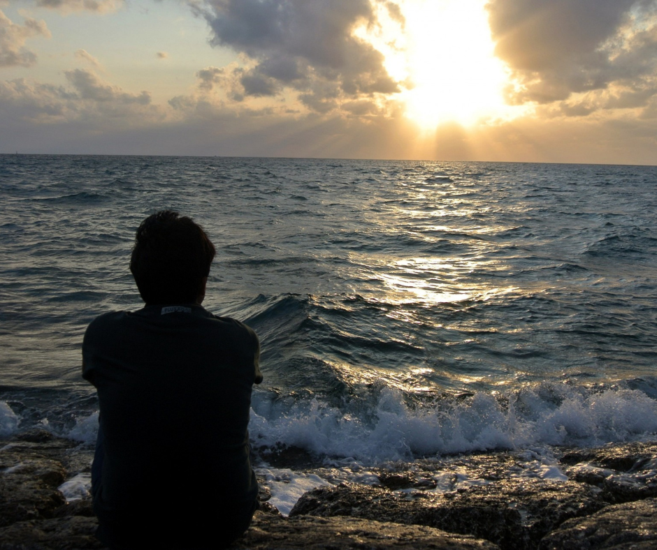 Someone sat on the beach watching the sunset